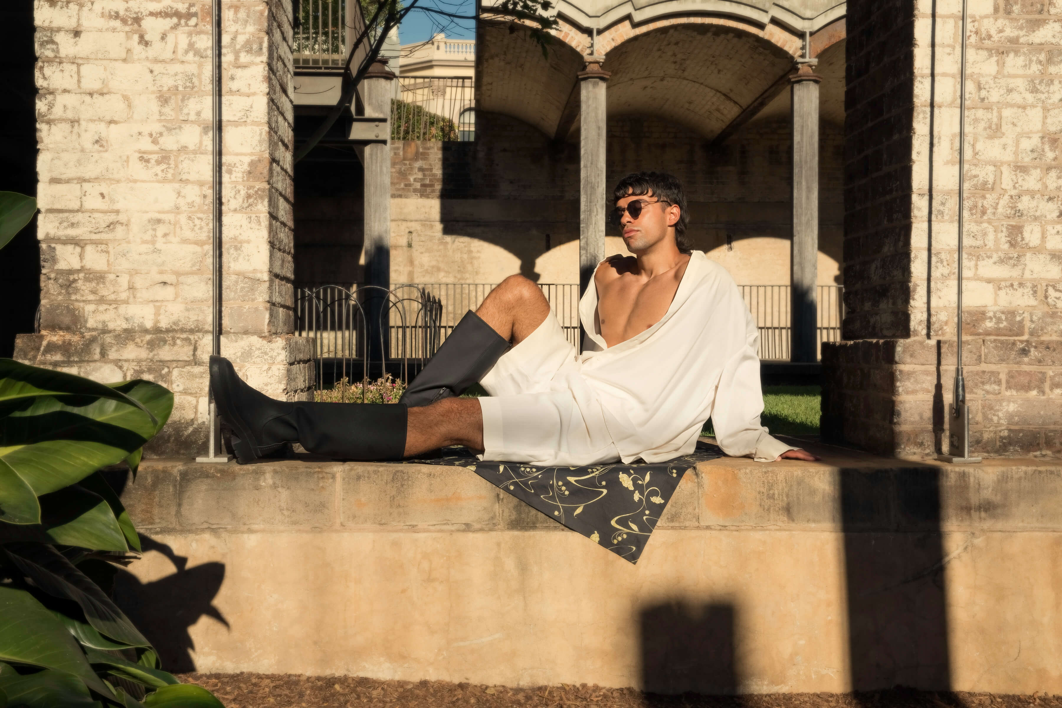 Model relaxes in the oversized atelier shirt & knee length shorts