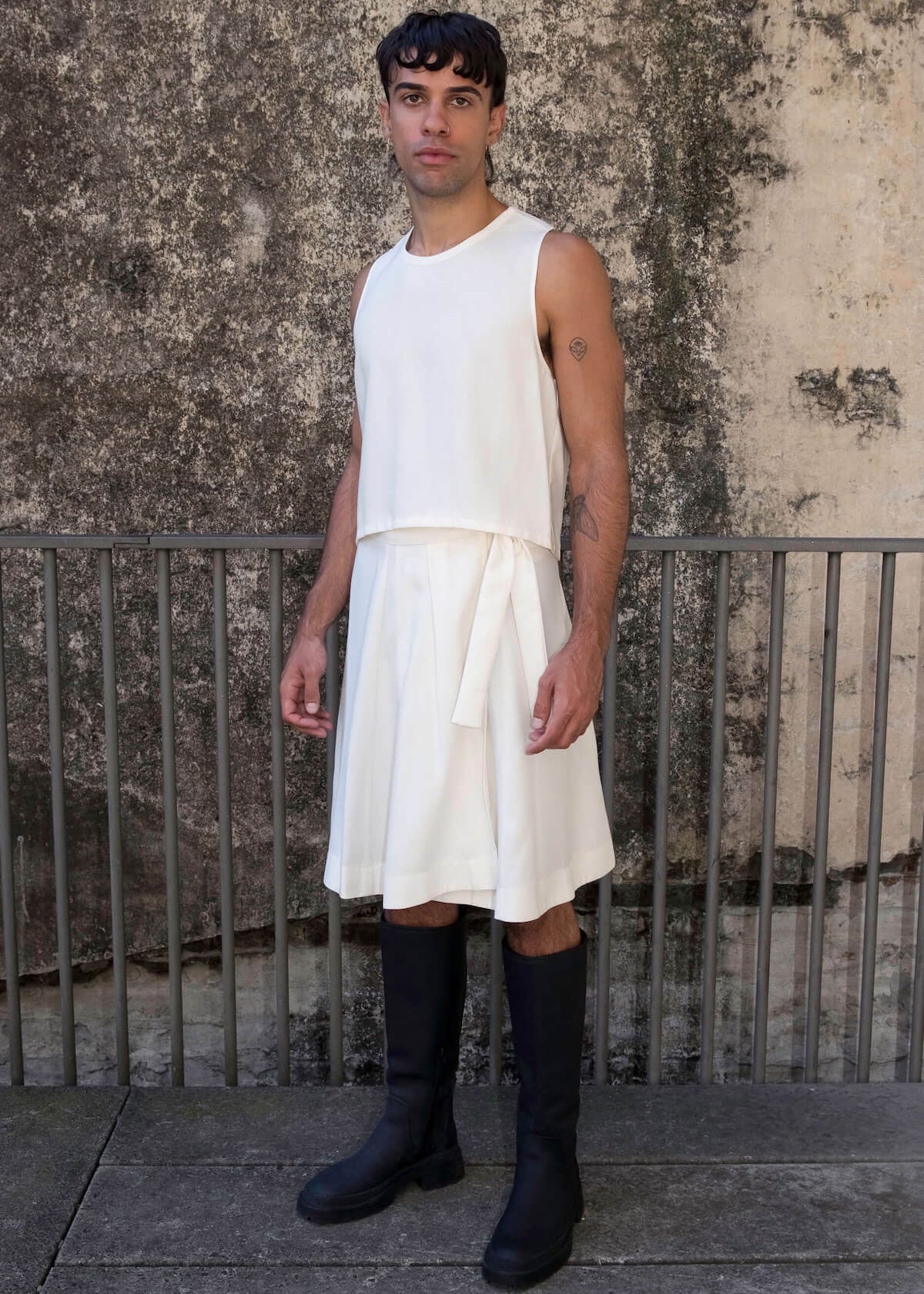The Glade model wears a men's skirt and cropped tank top for men